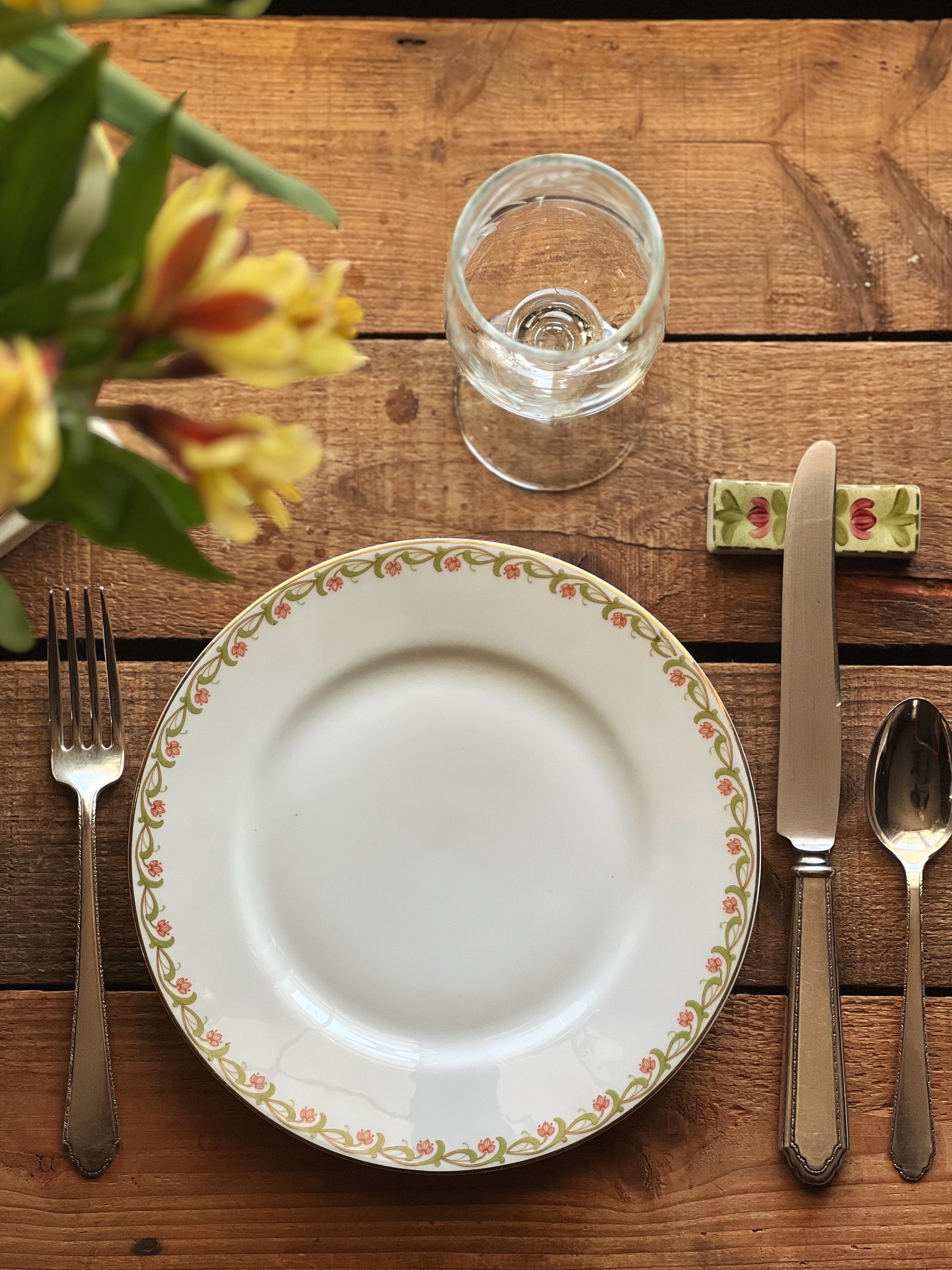 place setting at a table with a ceramic knife rest under the dinner knife