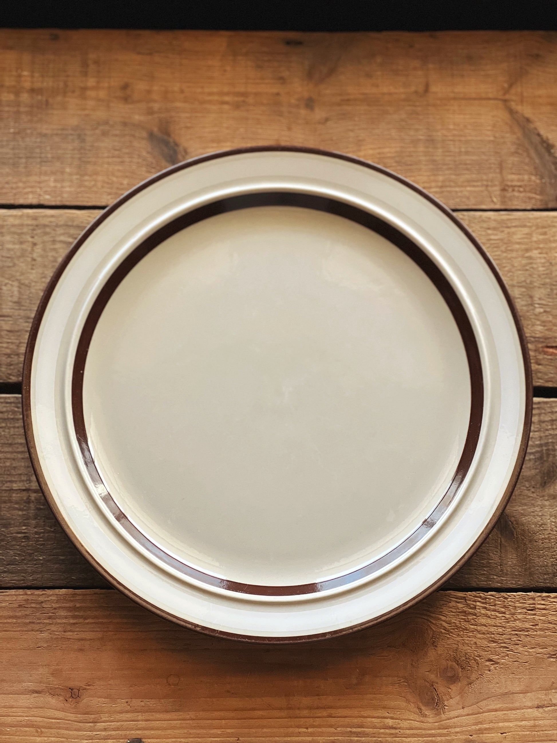 stoneware dinner plate with a white and brown banded rim design