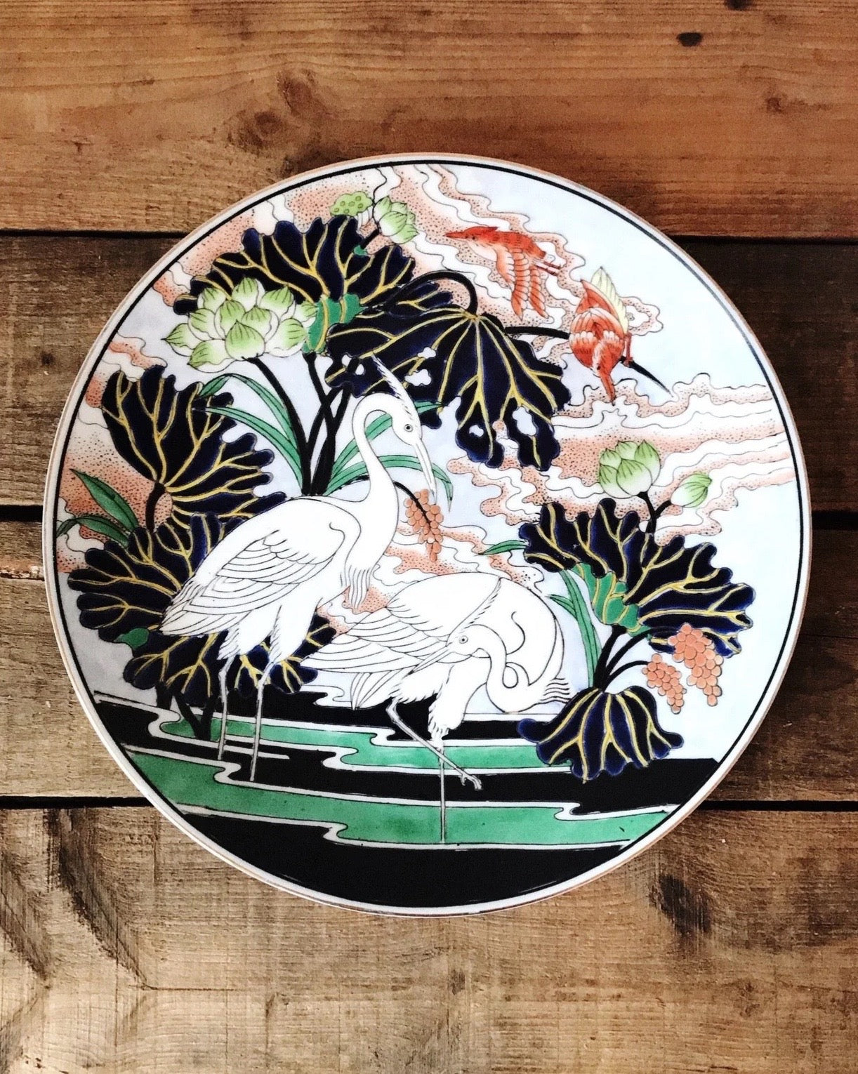decorative porcelain plate with cranes in navy, green and red
