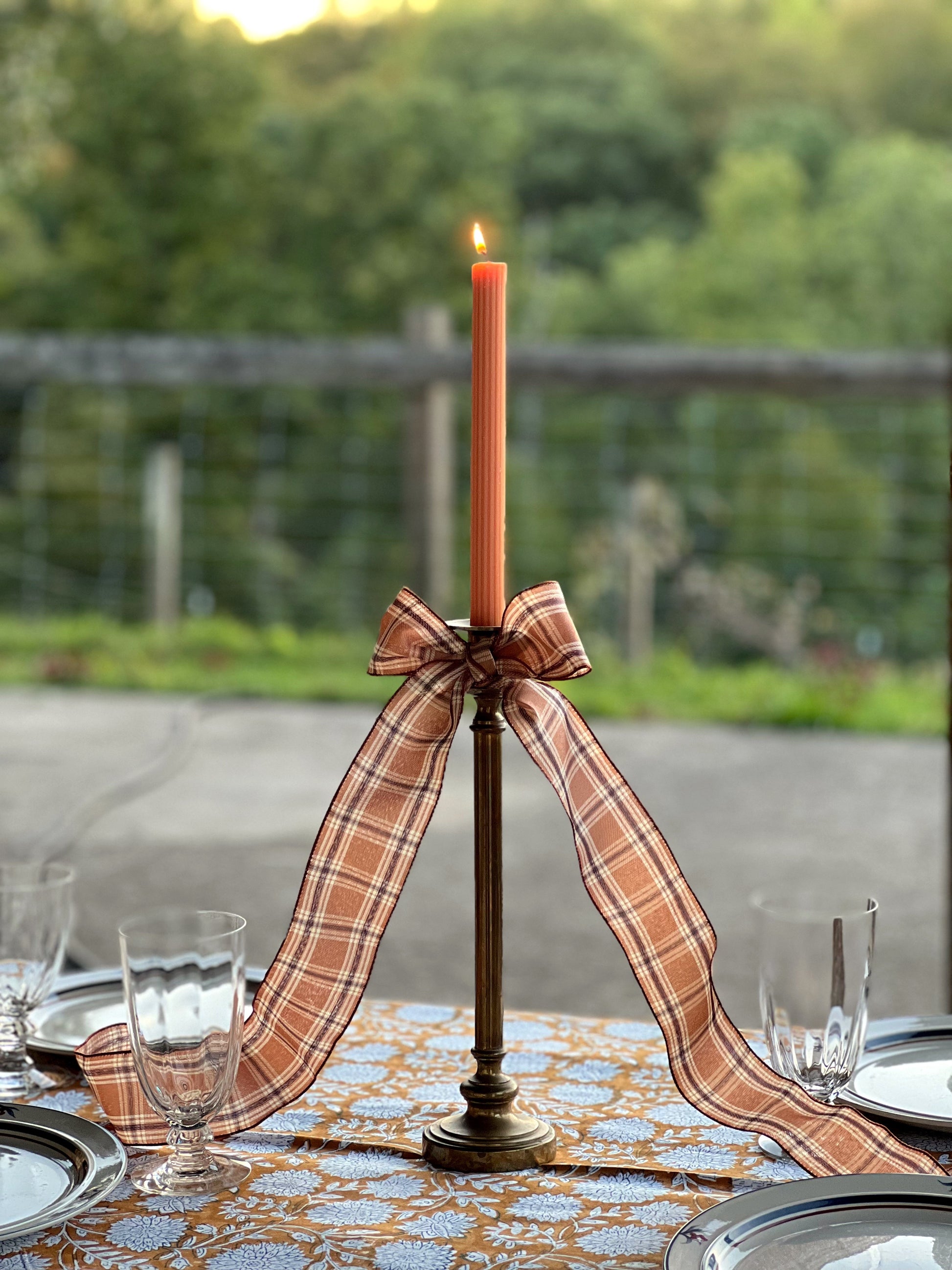 tall brass candleholder with a plaid bow