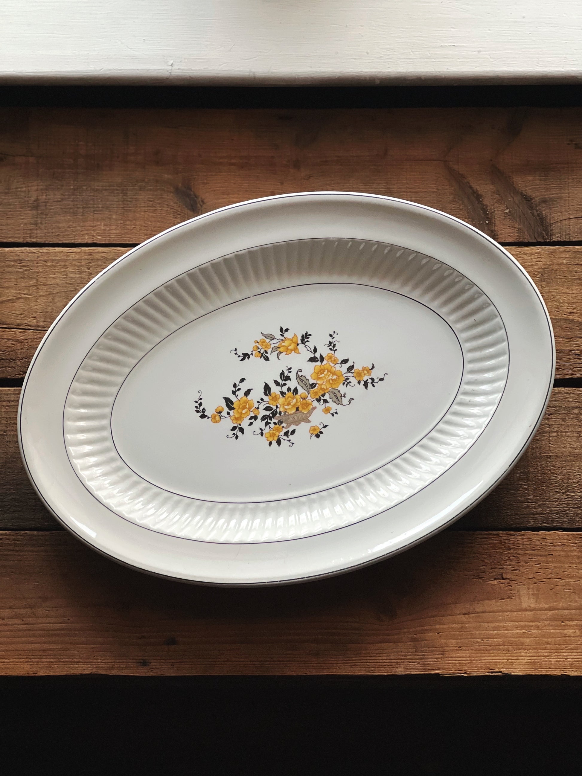 antique serving platter with a yellow gold and black floral design