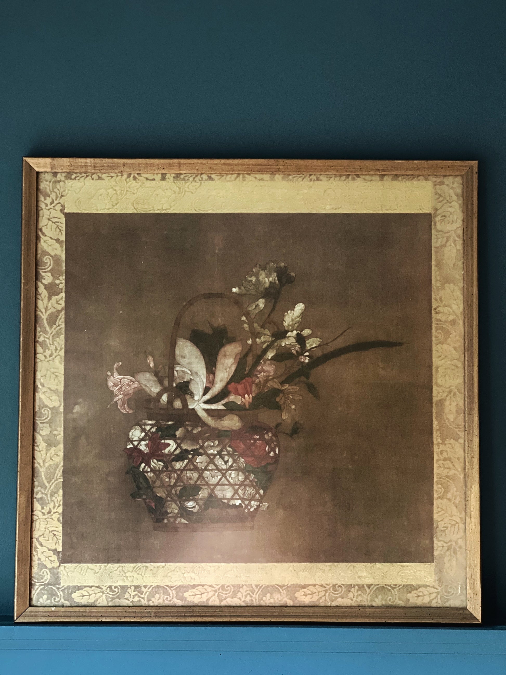 Framed artwork of a still life with flowers on a blue background