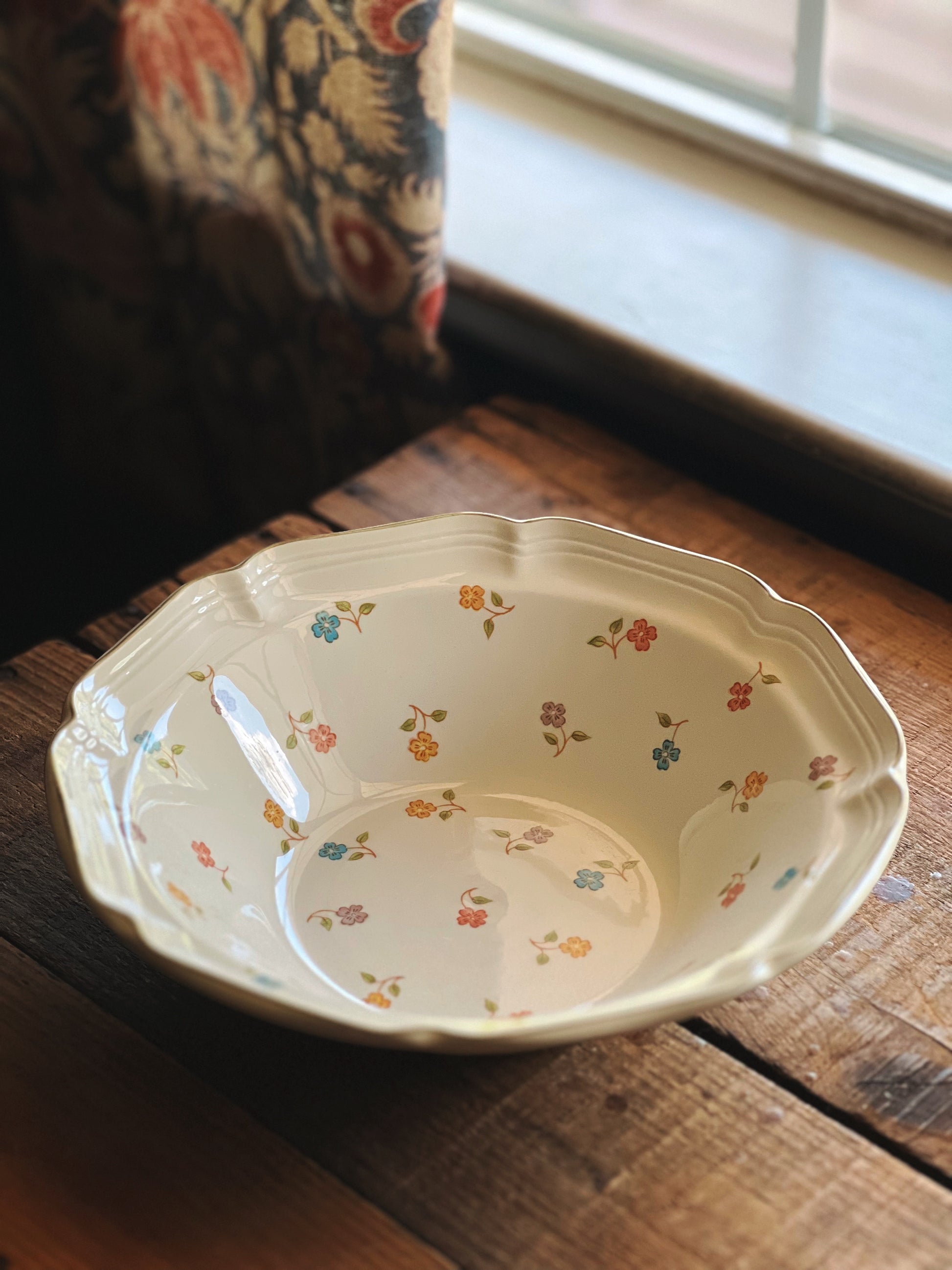 Decorative ceramic bowl with floral patterns on a wooden surface