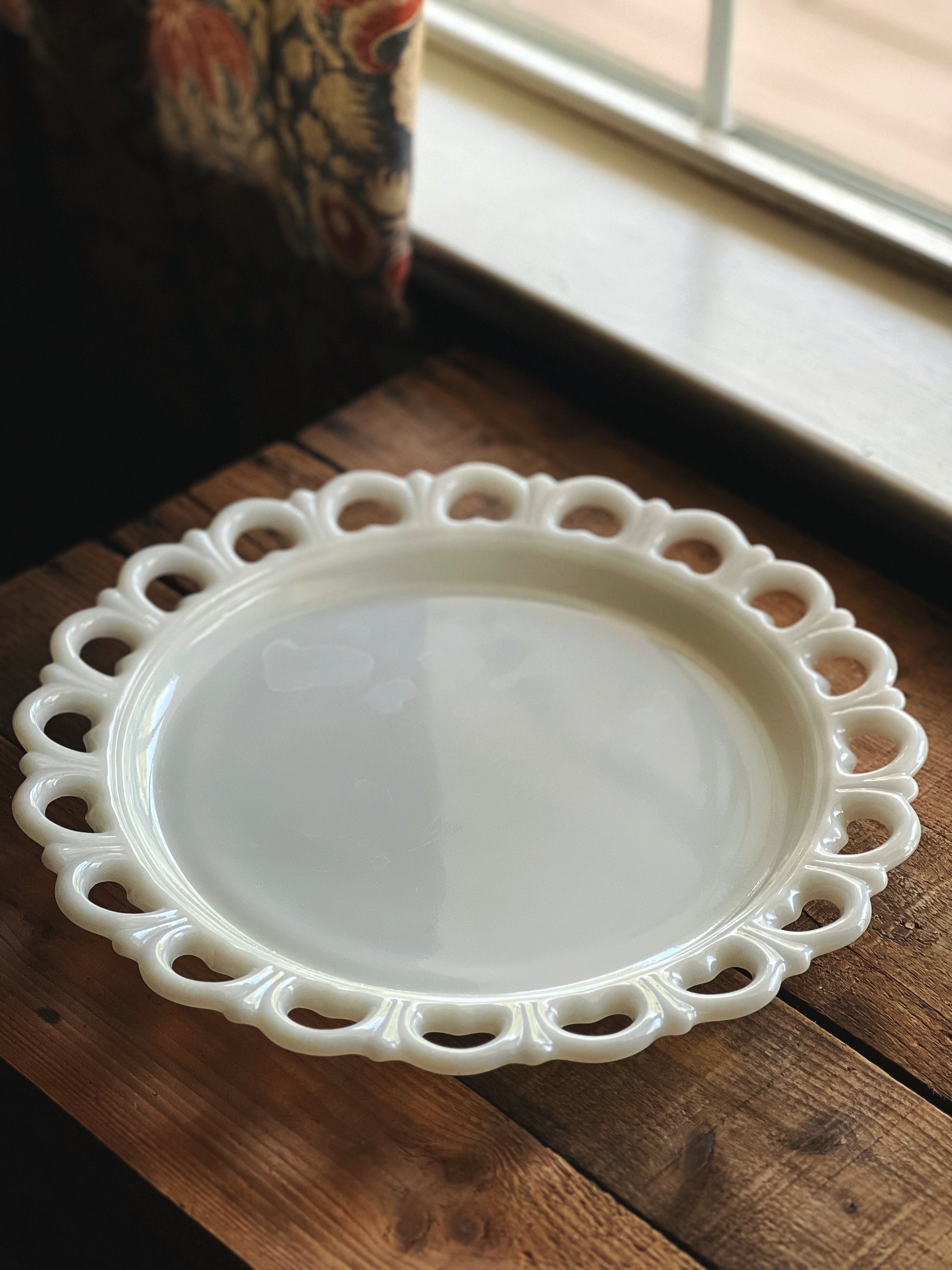 White decorative plate on a wooden surface with a blurred background