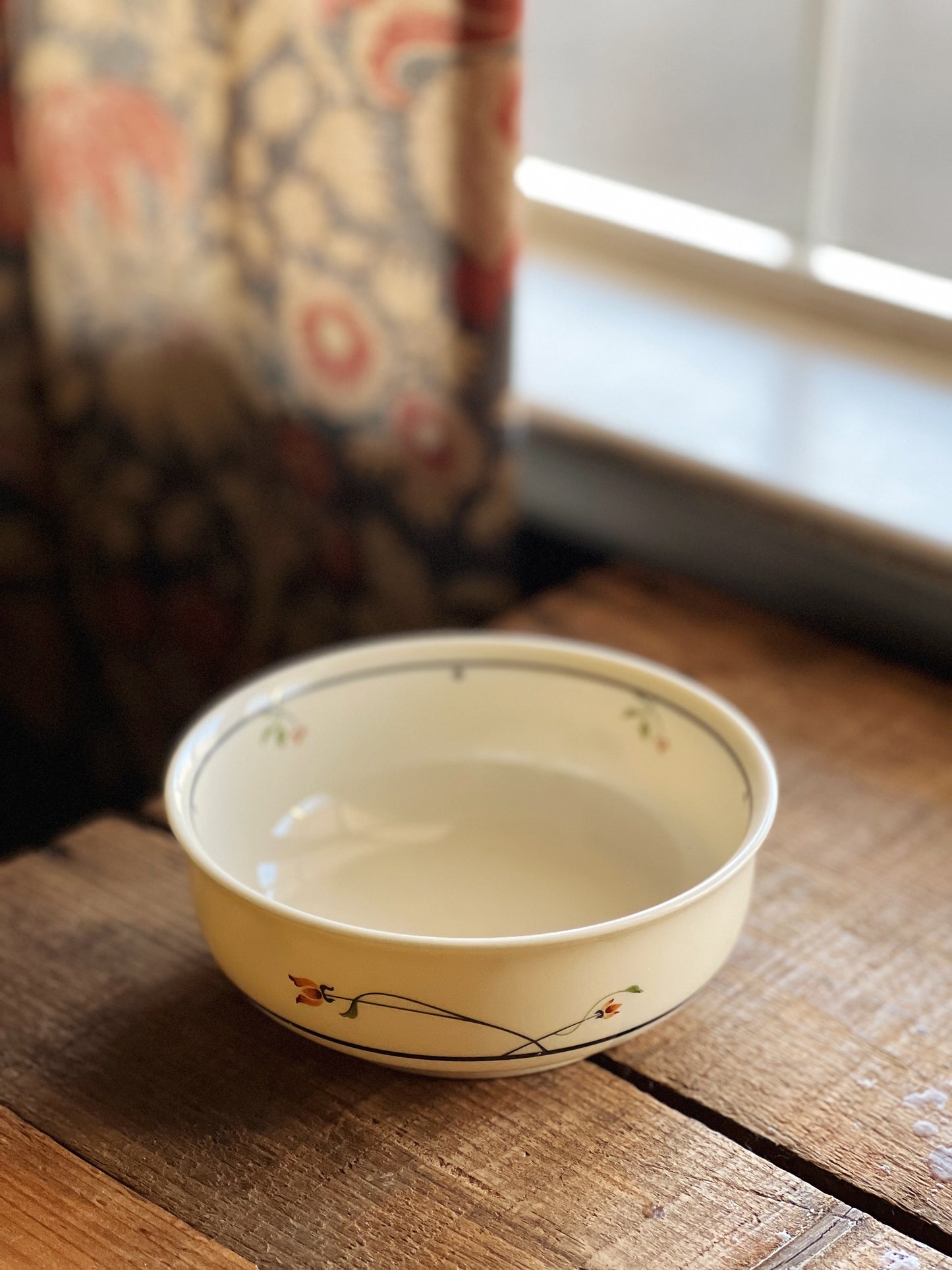 white cereal bowl with a navy and orange floral design
