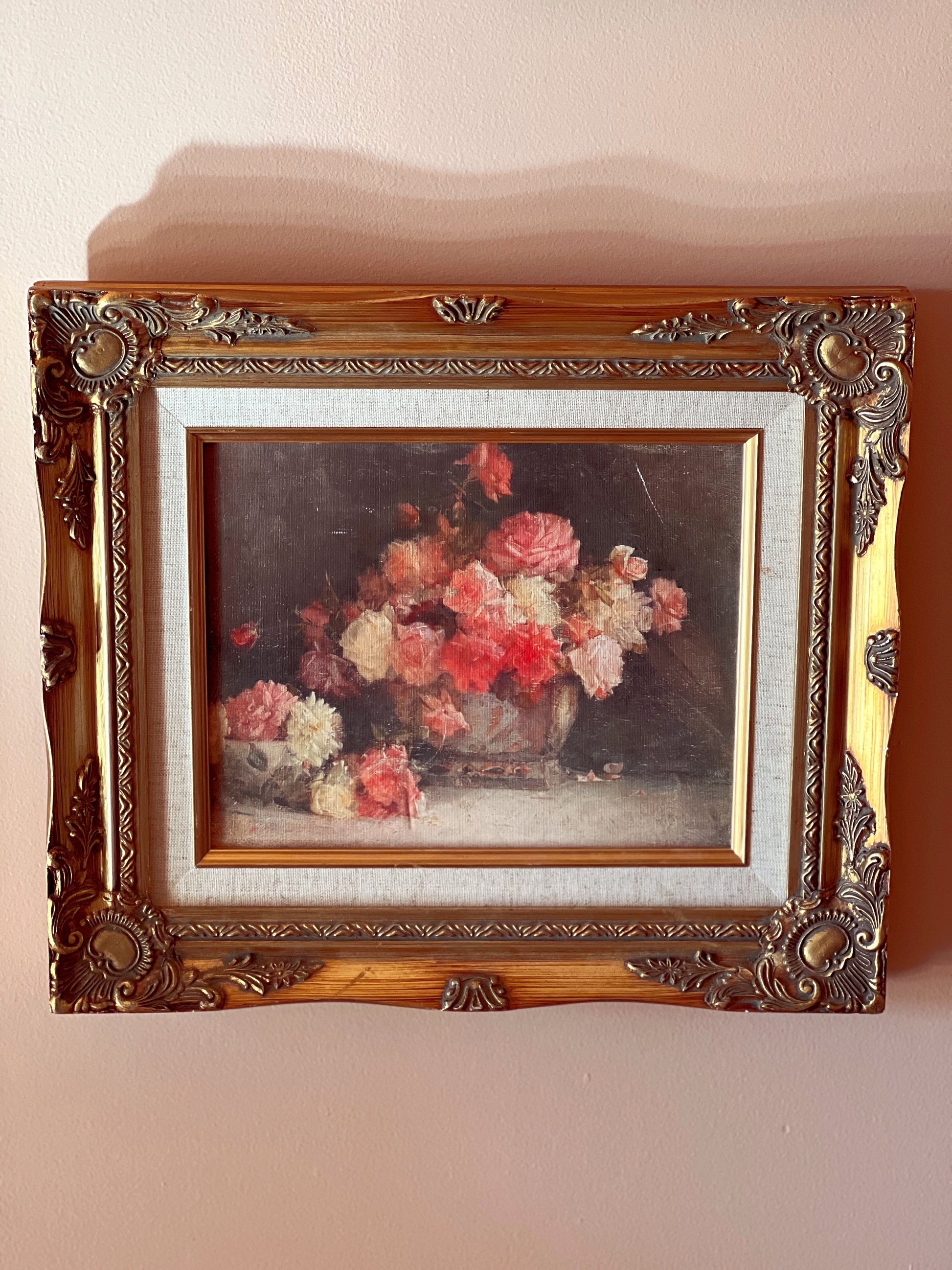 Framed painting of a floral still life on a beige wall