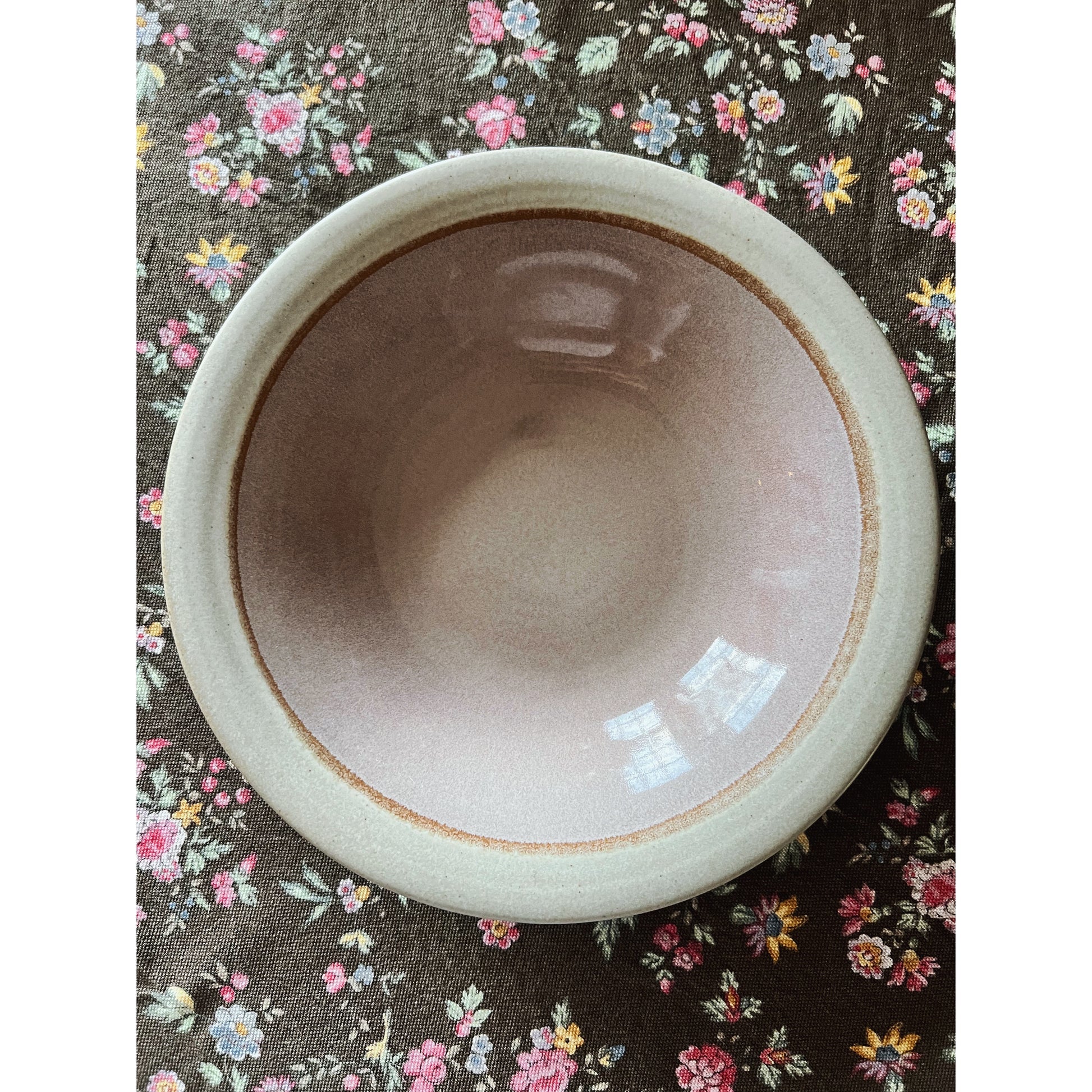 stoneware soup bowl with a pink center on a floral background