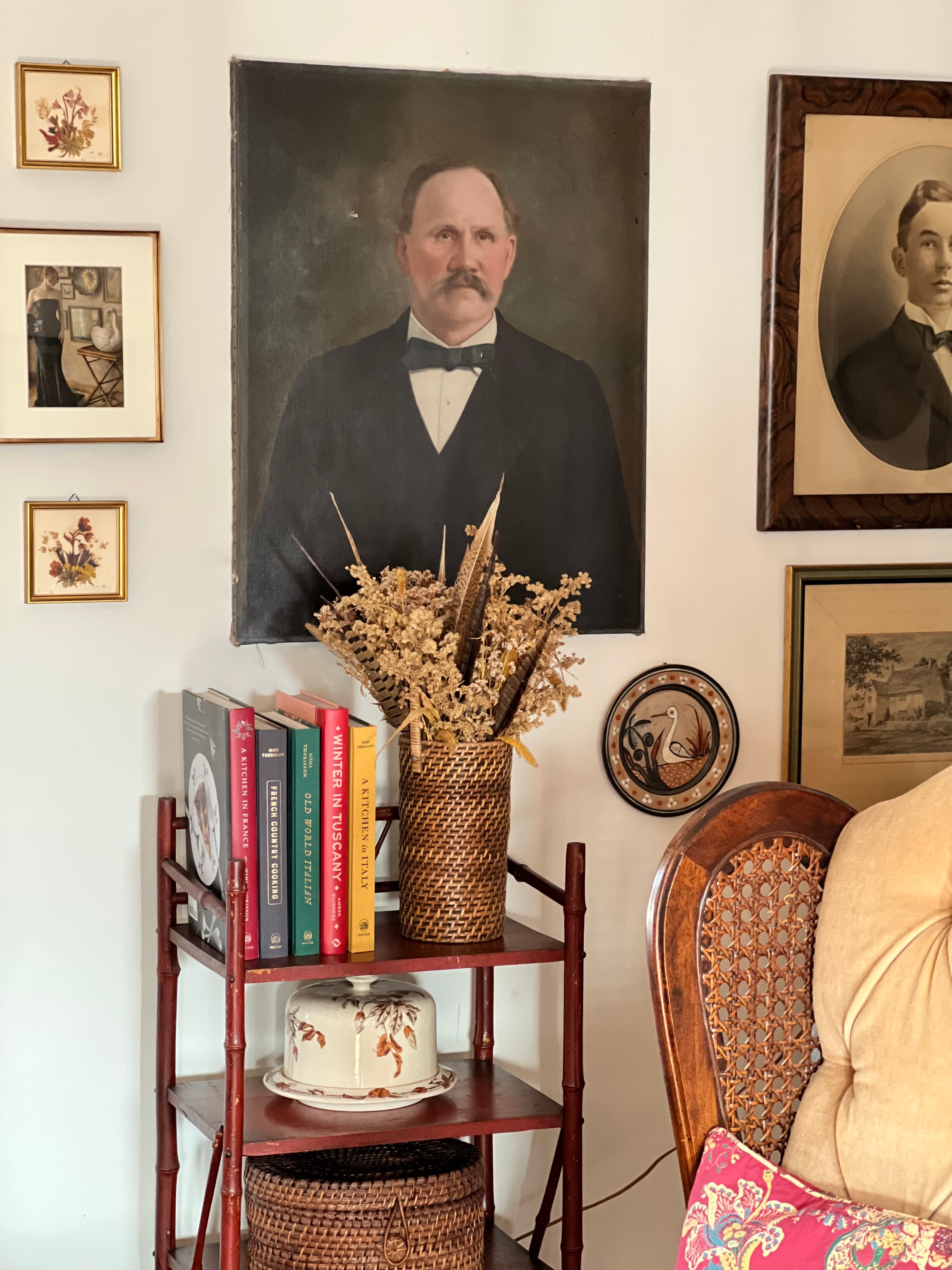 collected antique portraits and vintage wall art in a layered home interior