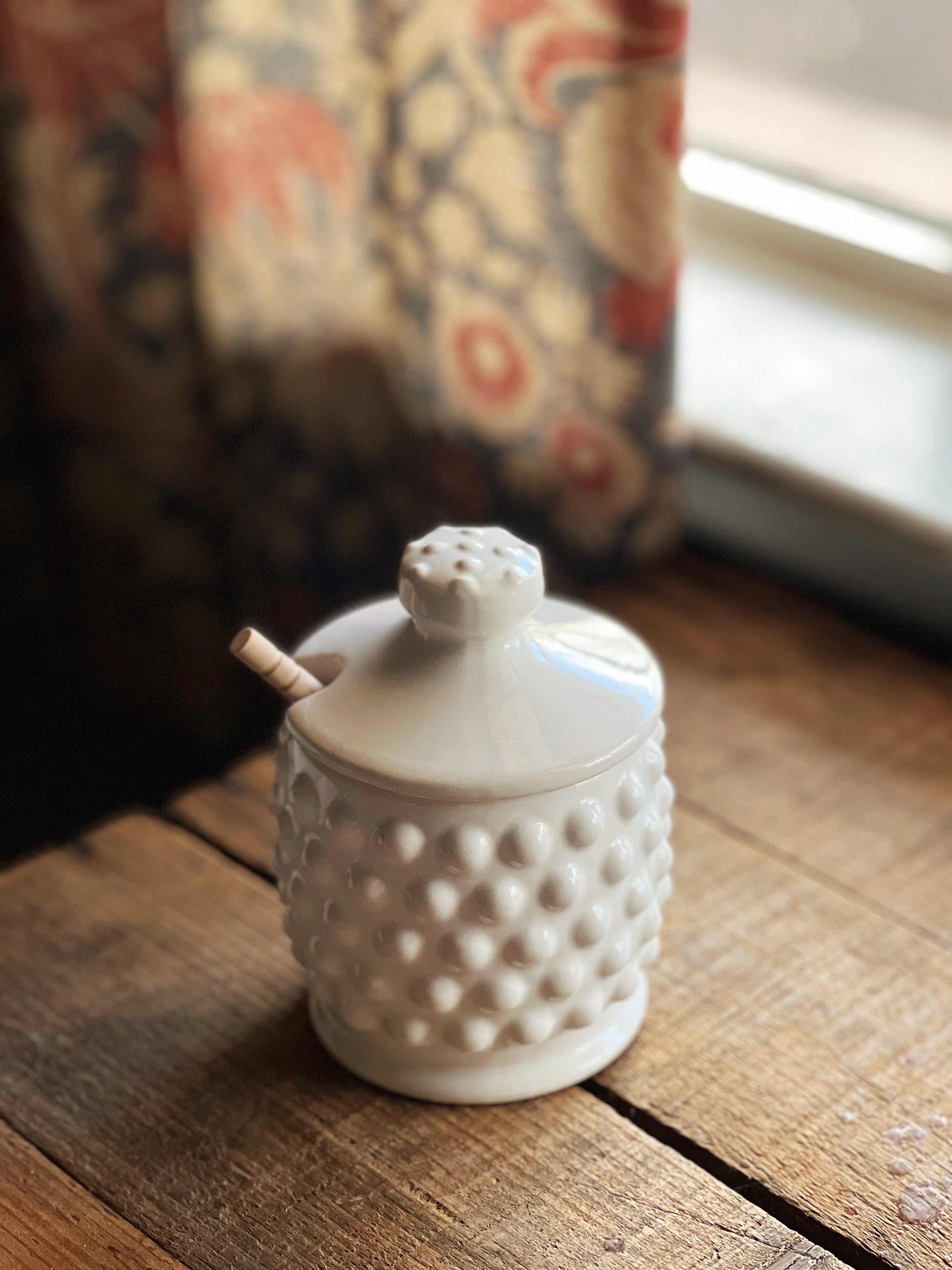 white hobnail honey pot with wooden dipper