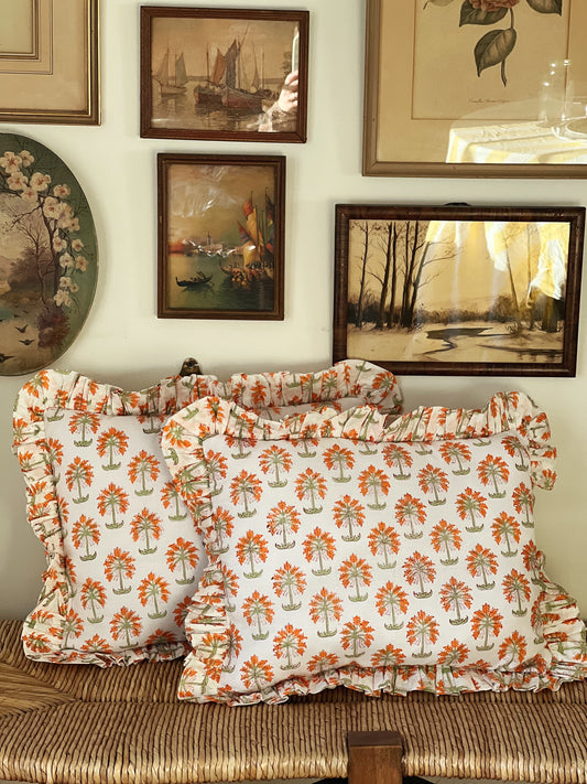 throw pillows in tangerine and white with a ruffled edge