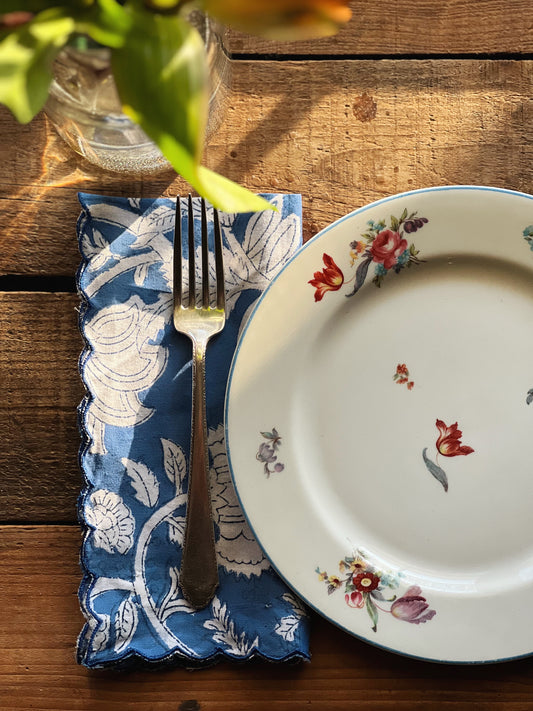 blue and white floral block print napkin with a multi color floral plate