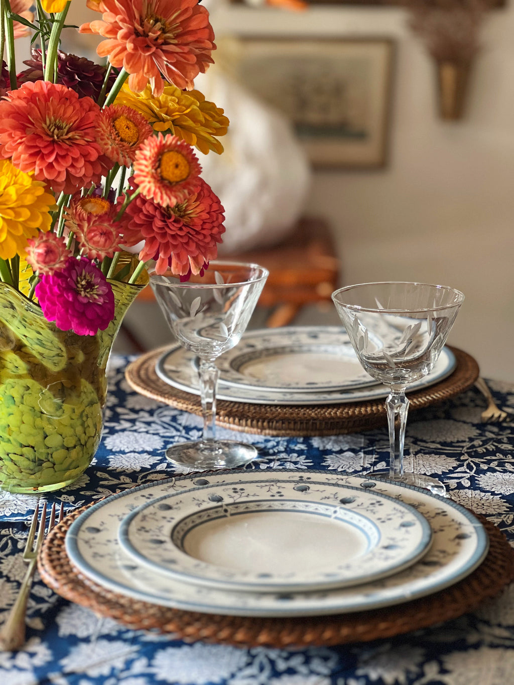 etched glass champagne coupes on a table set with blue and white dishes