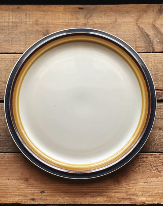 round stoneware platter with a navy blue rim