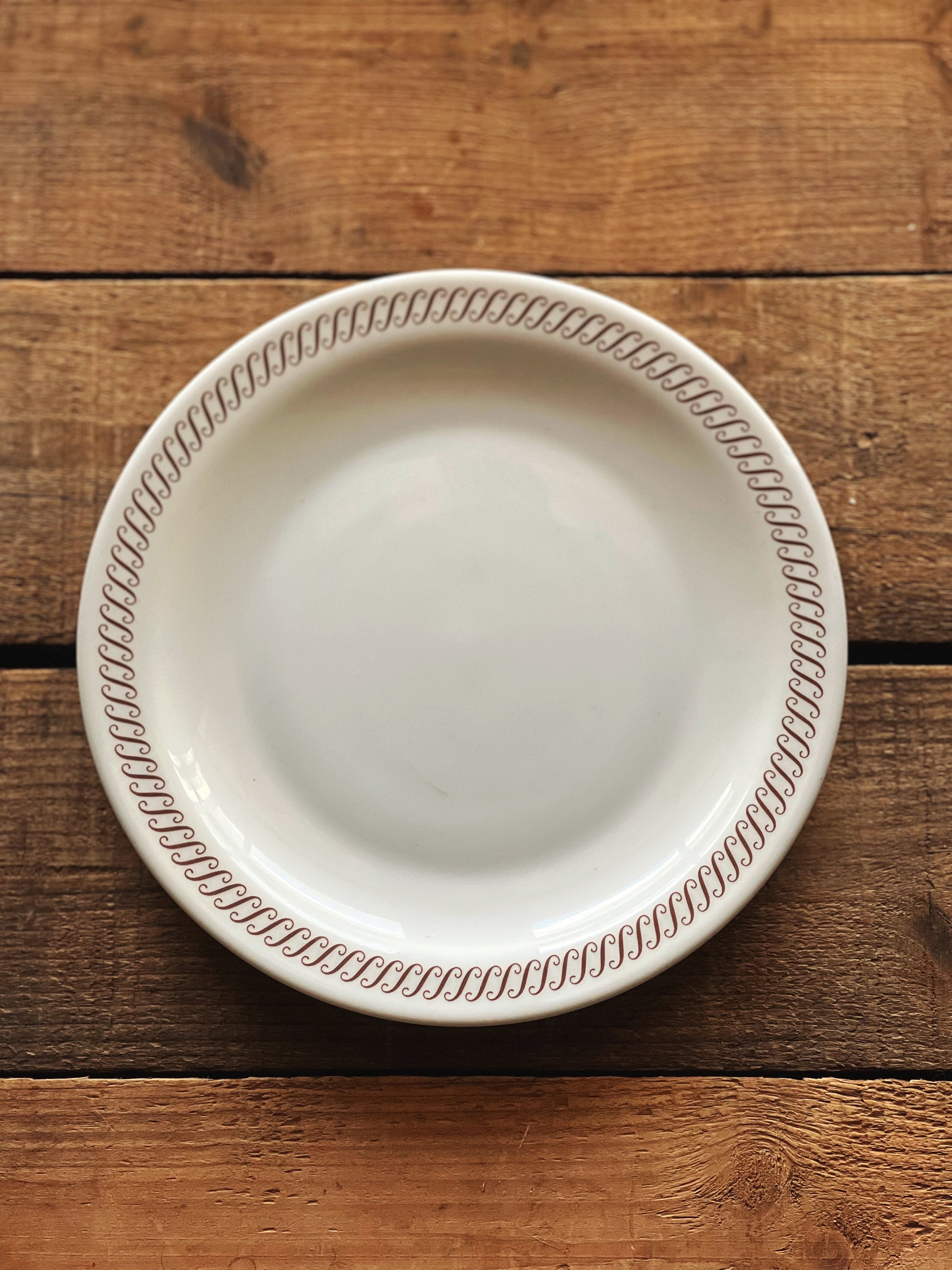 white milk glass plate with a gold/brown rim