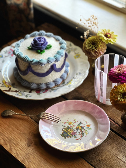 vintage cake plate with a bird design and pink rim