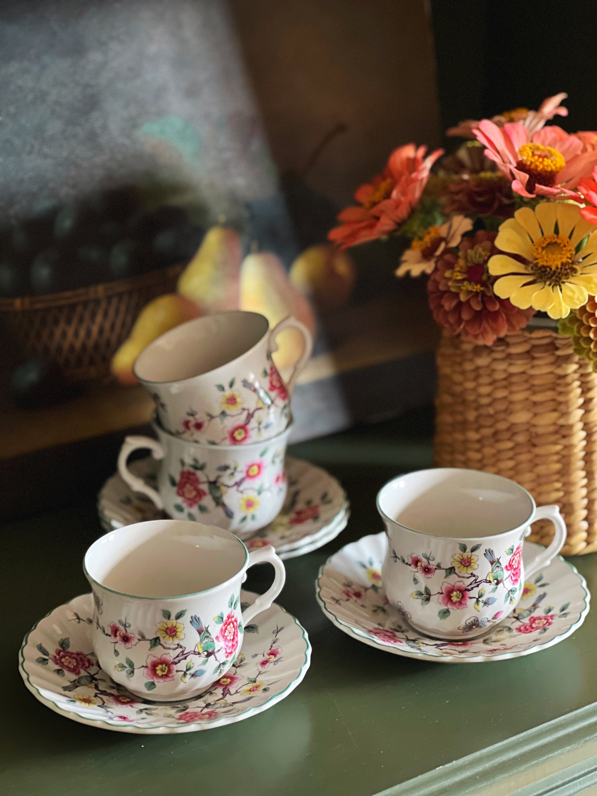 vintage Chinese Rose teacups and saucers on a shelf