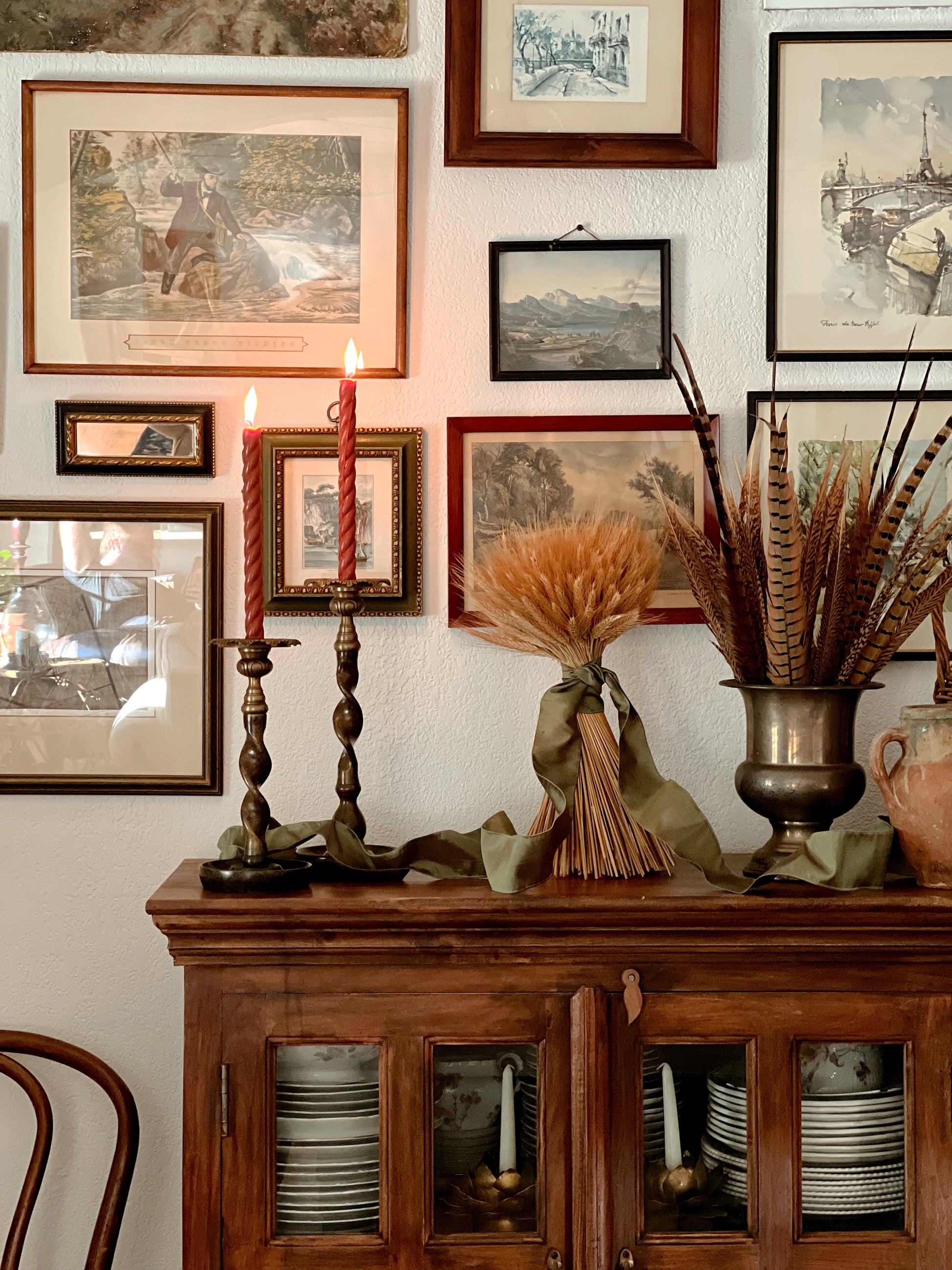 pair of brass and bronze barley twist candleholders on an autumnal bookcase