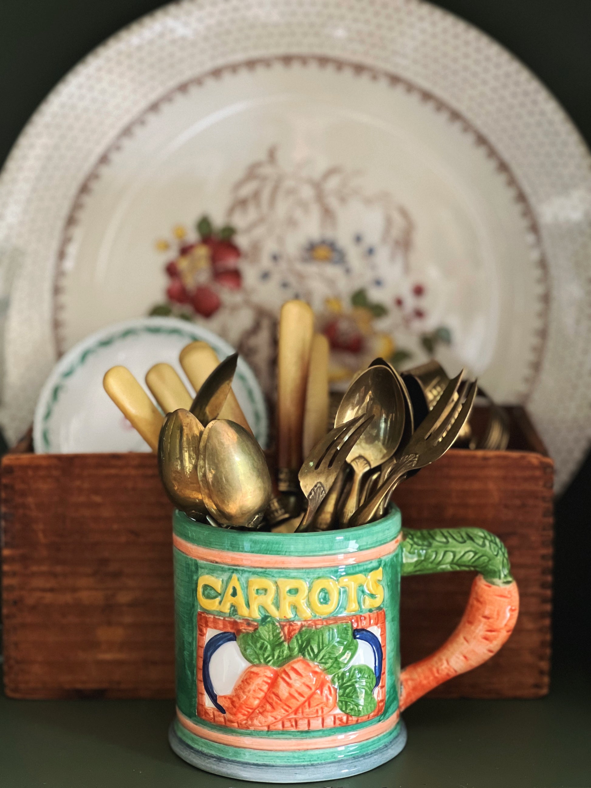 colorful ceramic mug holding some brass flatware