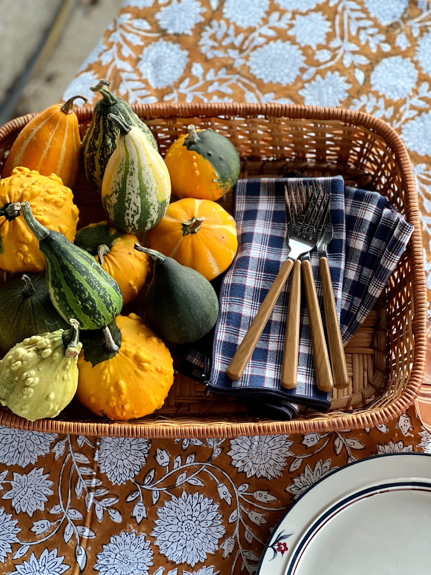 navy plaid napkins in a basket with pumpkins and gourds