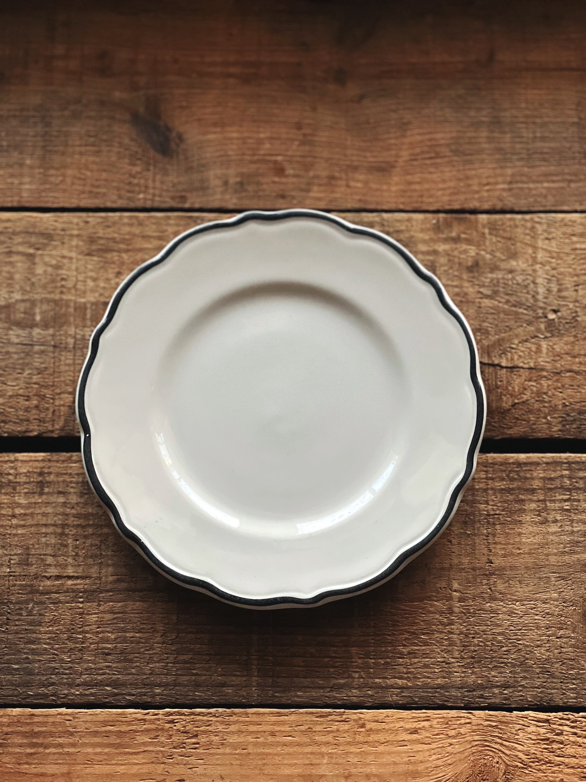 desert plate with a scalloped edge and black rim