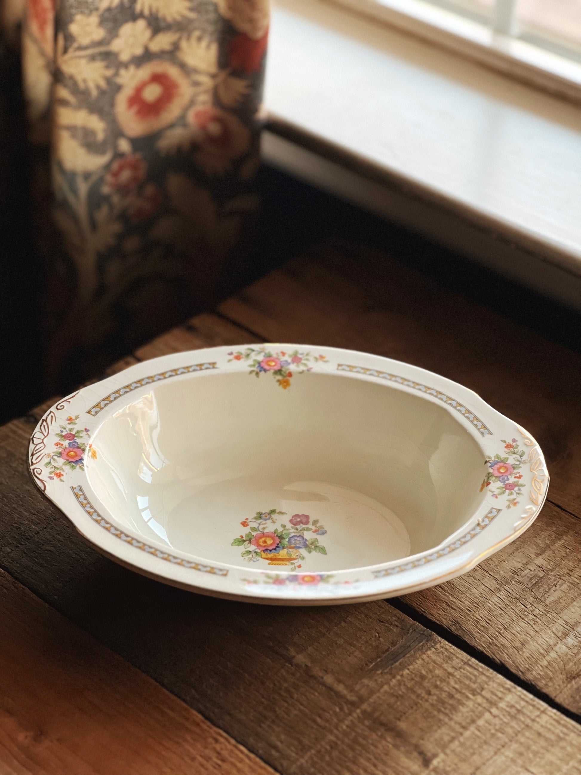 Decorative ceramic bowl with floral patterns on a wooden surface