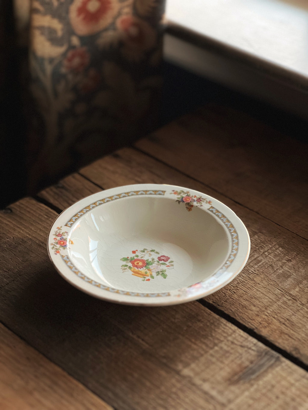 Decorative ceramic bowl with floral pattern on a wooden surface
