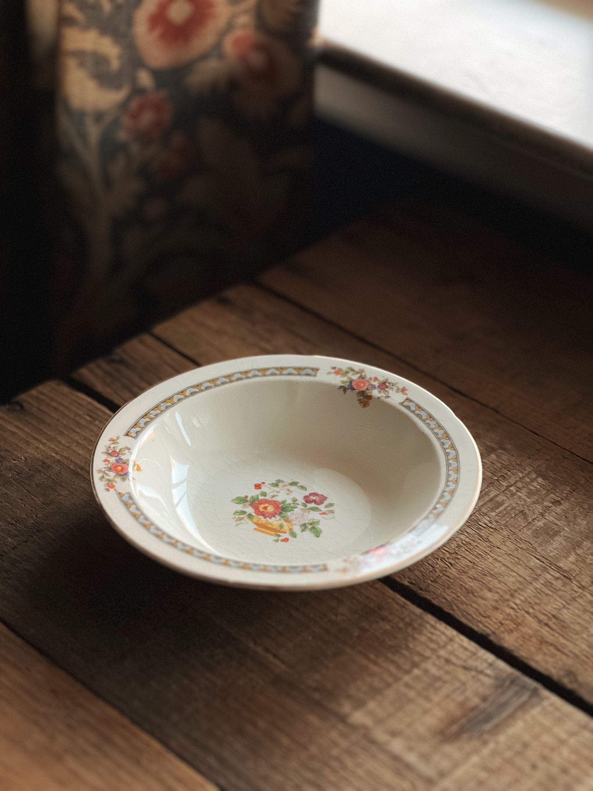 Decorative ceramic bowl with floral pattern on a wooden surface