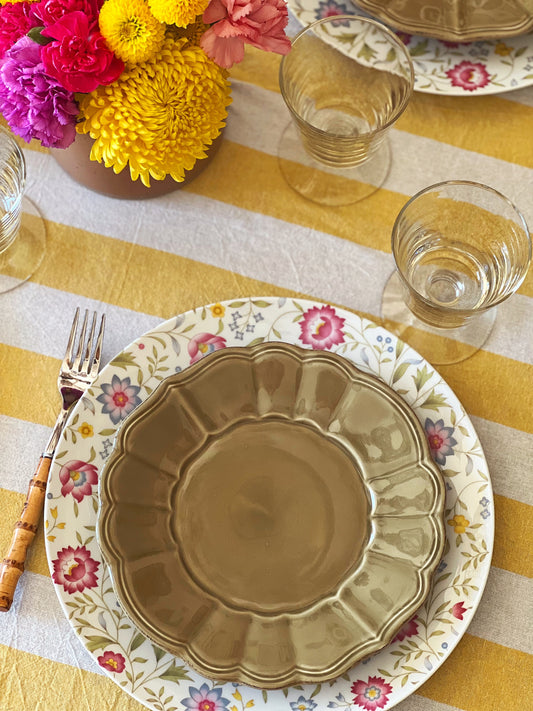 floral dinner plate with a green scalloped salad plate on top set on a table
