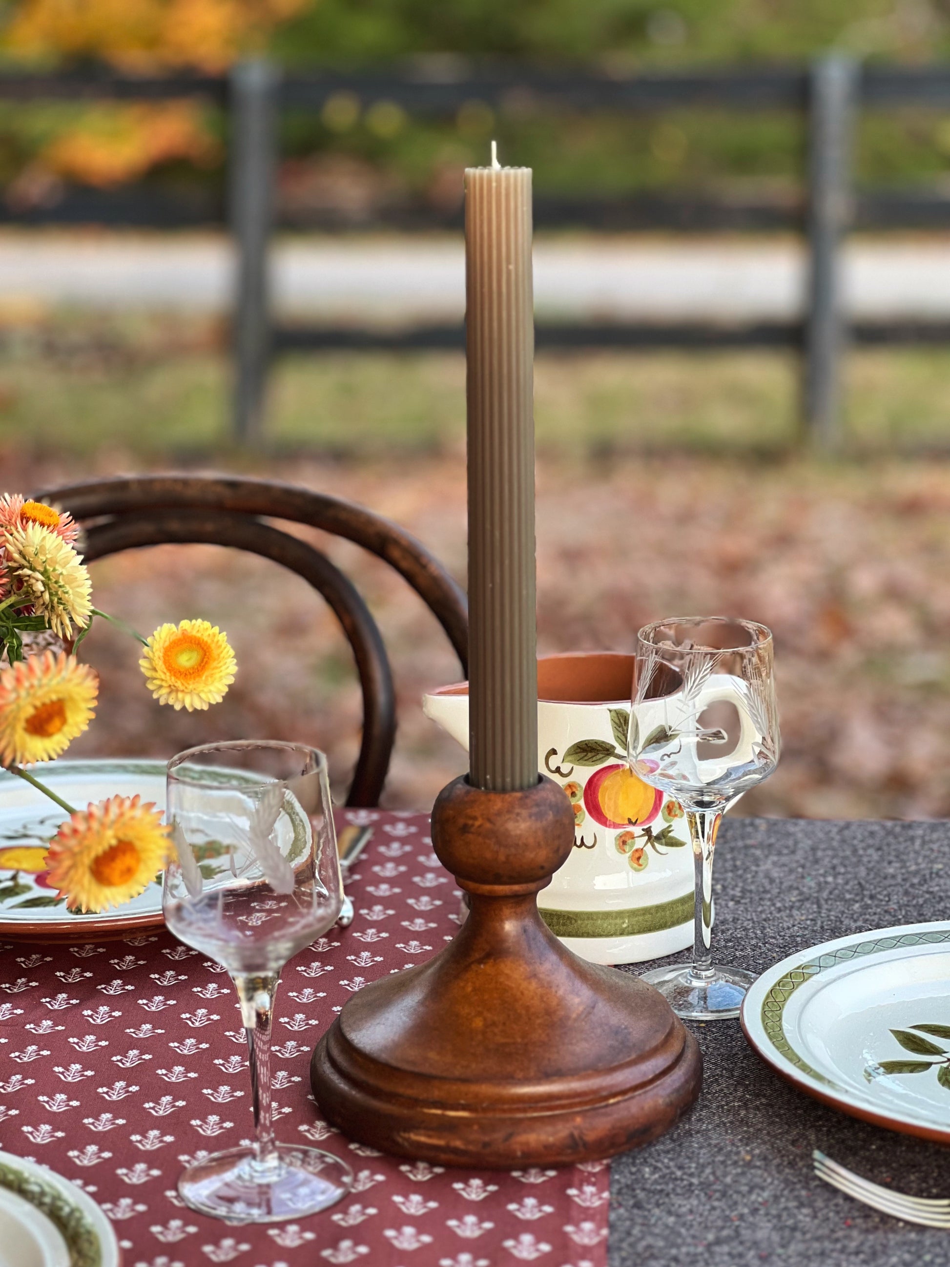 large wood candleholder on a table outside in fall