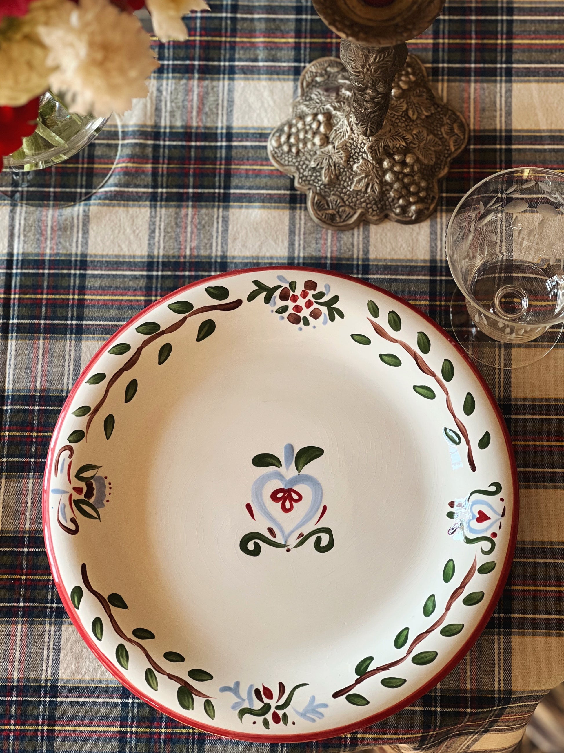 hand painted Christmas dinner plate on a table with a plaid tablecloth