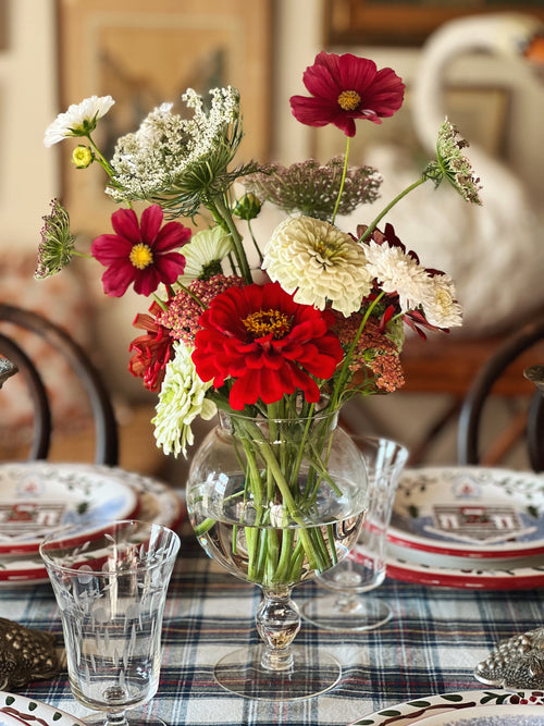 fishbowl style vase on a table set with Christmas dishes