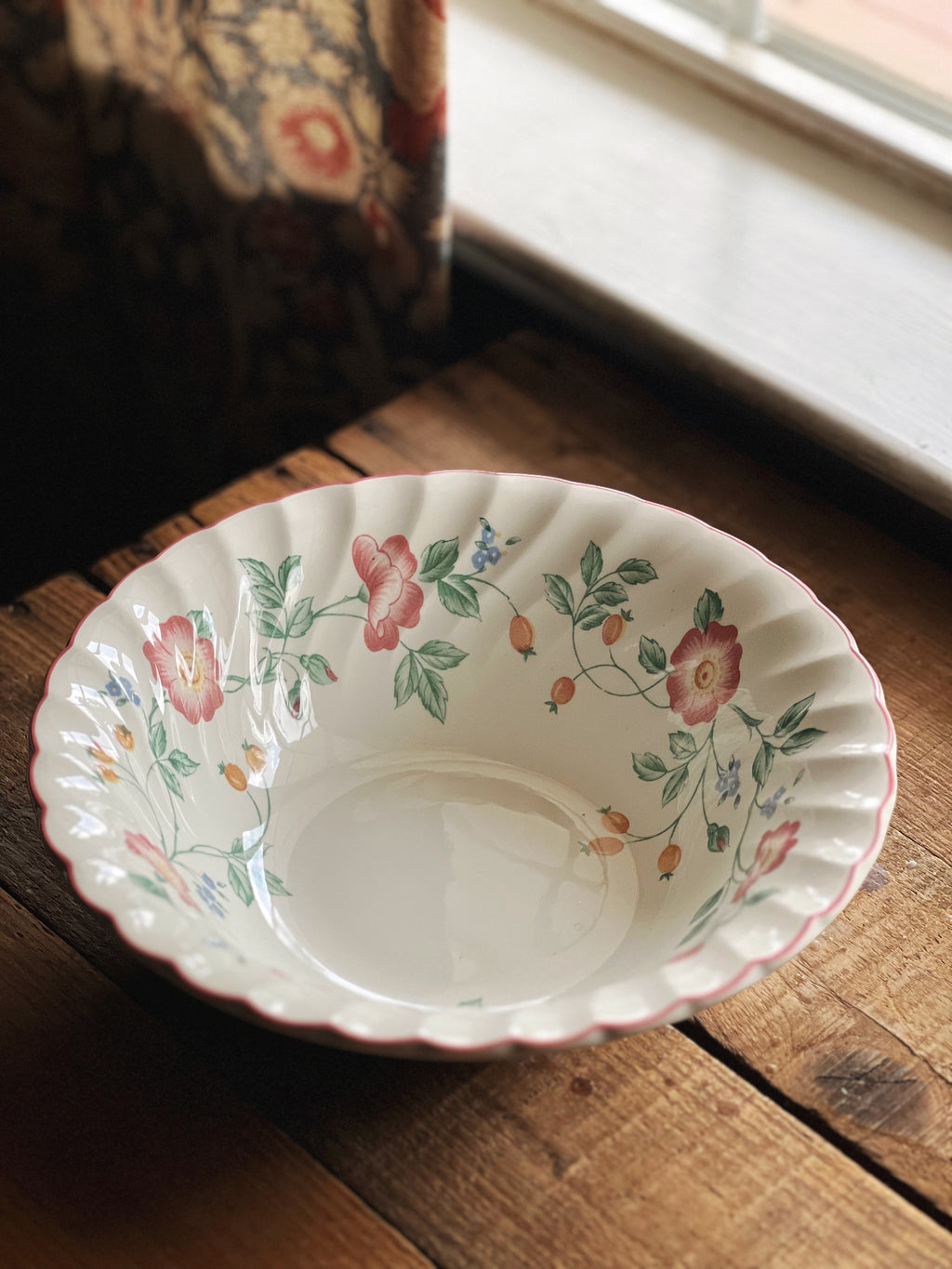 Decorative ceramic bowl with floral patterns on a wooden surface