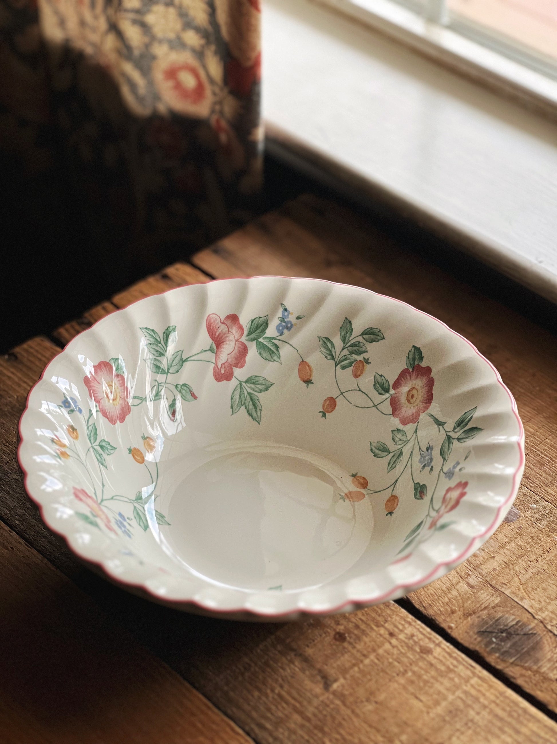 Decorative ceramic bowl with floral patterns on a wooden surface