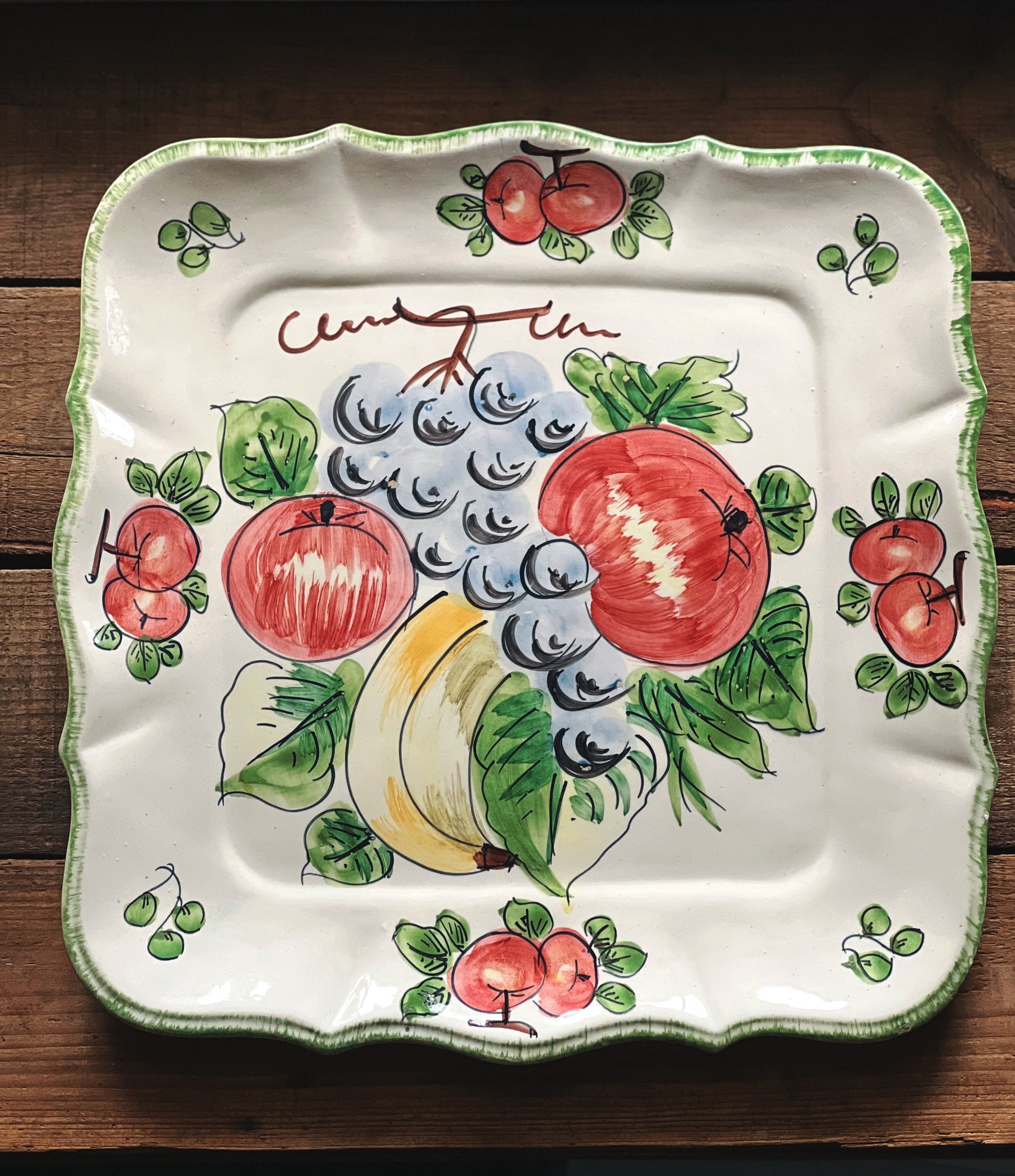 Decorative plate with fruit design on a wooden surface