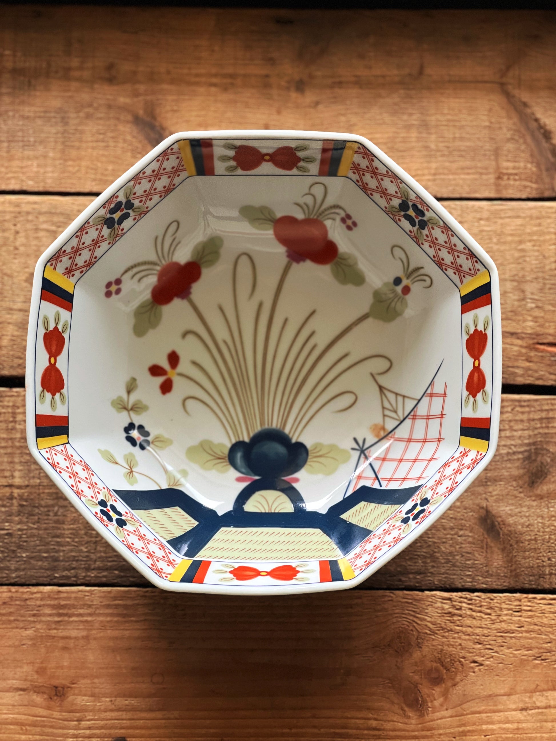 Decorative ceramic plate with floral design on a wooden surface
