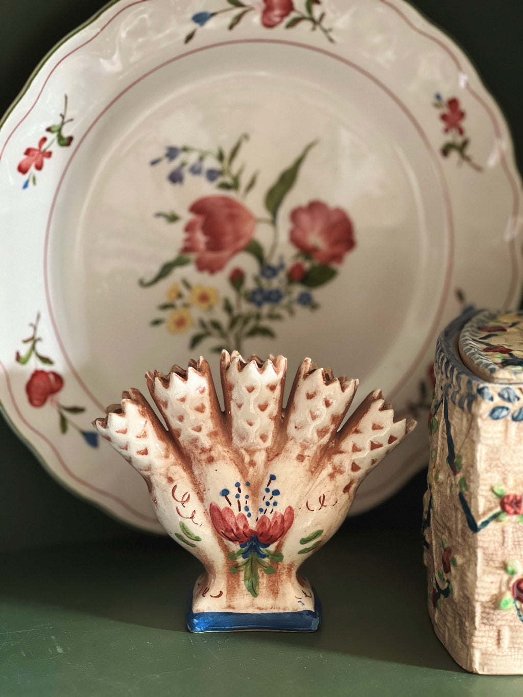 Decorative ceramic piece with floral design on a matching plate and box.