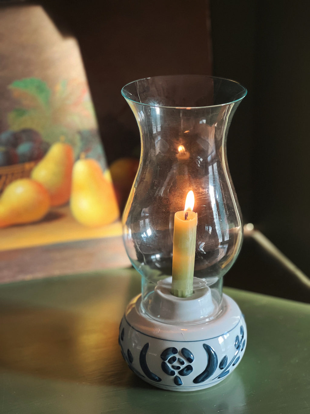 Candle in a glass holder on a table with a blurred background