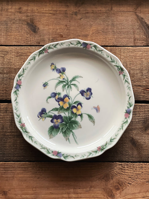 Decorative plate with floral design on a wooden surface