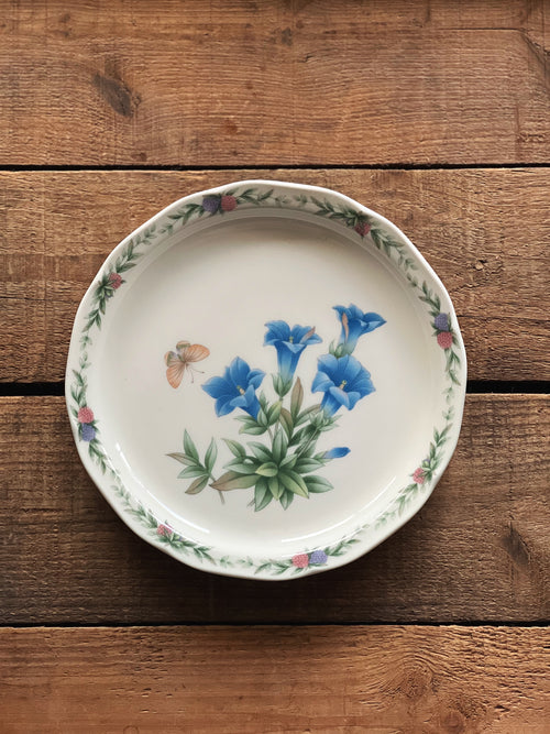Decorative ceramic plate with floral design on a wooden surface