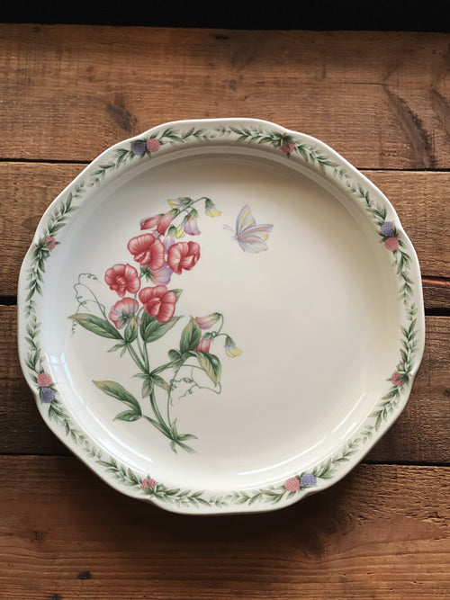 Decorative ceramic plate with floral design on a wooden surface
