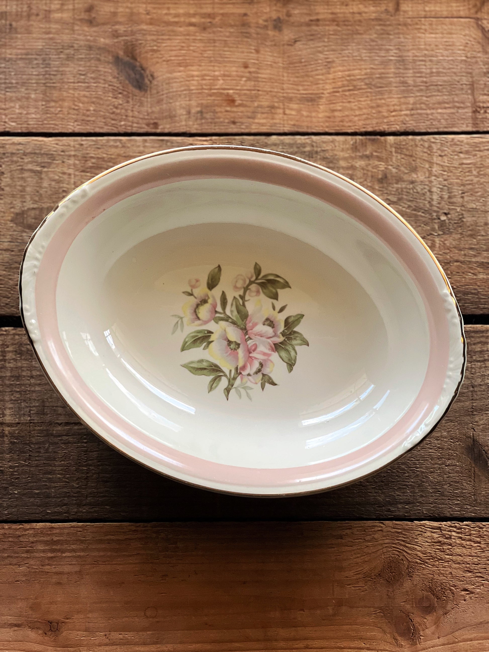 Decorative ceramic dish with floral design on a wooden surface