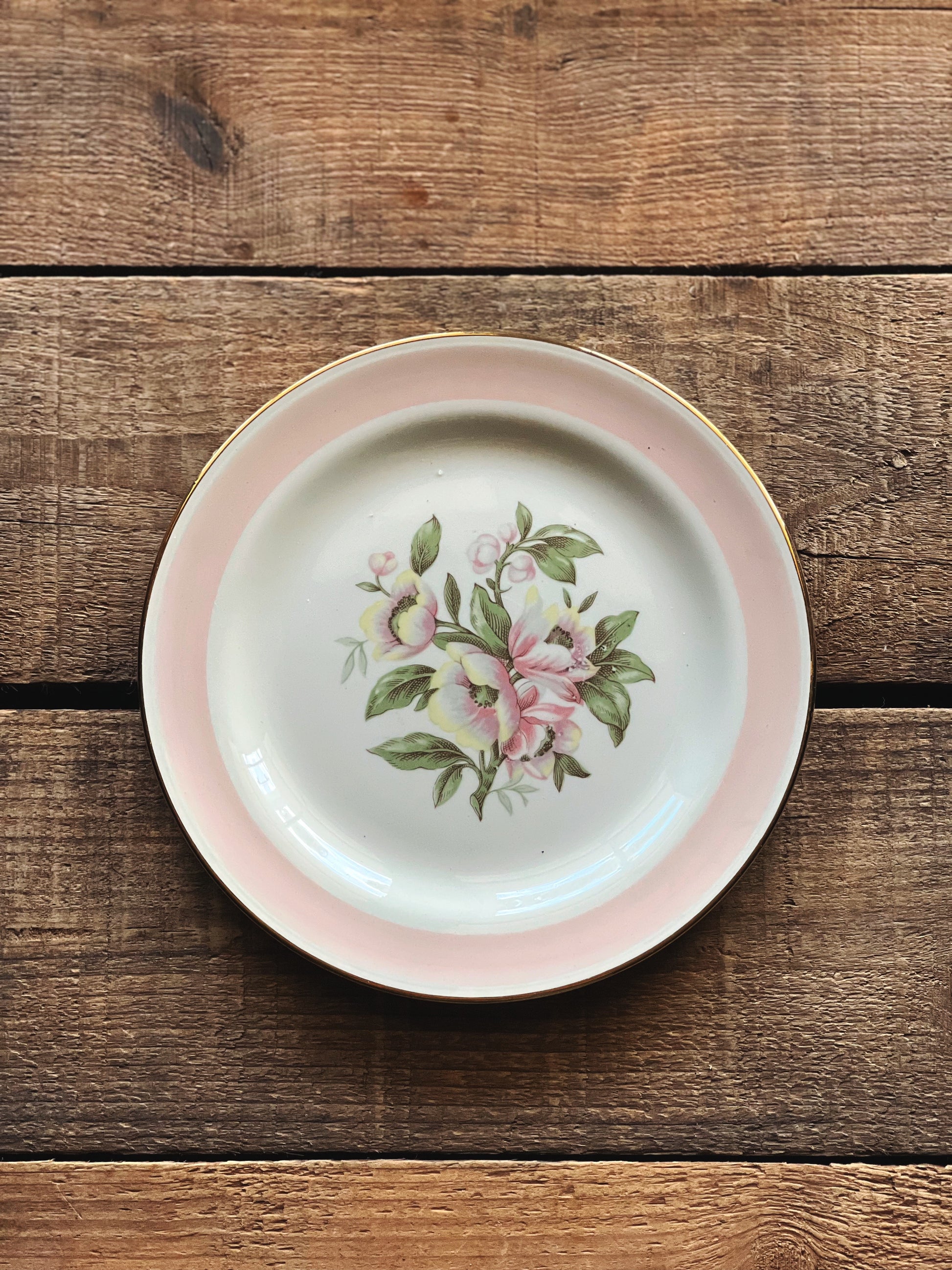 Small ceramic plate with floral design on a wooden surface
