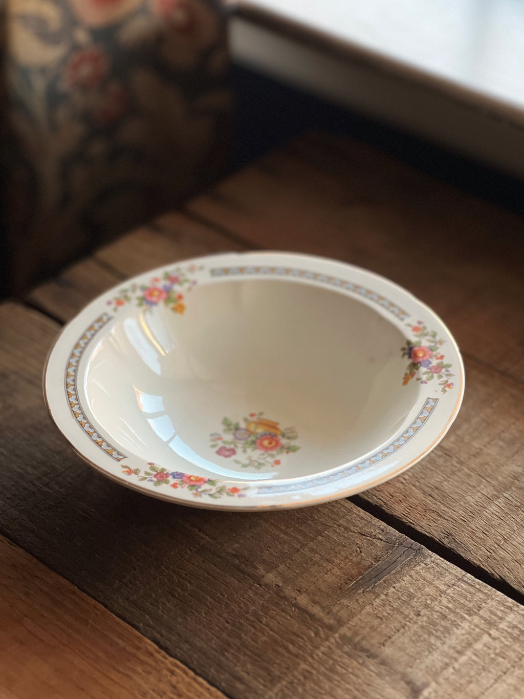 Decorative ceramic bowl with floral patterns on a wooden surface