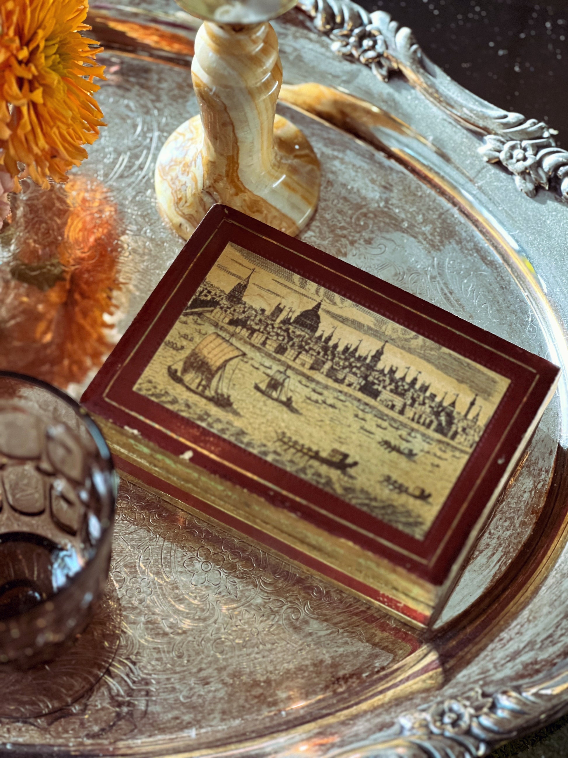Vintage-style card with cityscape illustration on a decorative tray with flowers