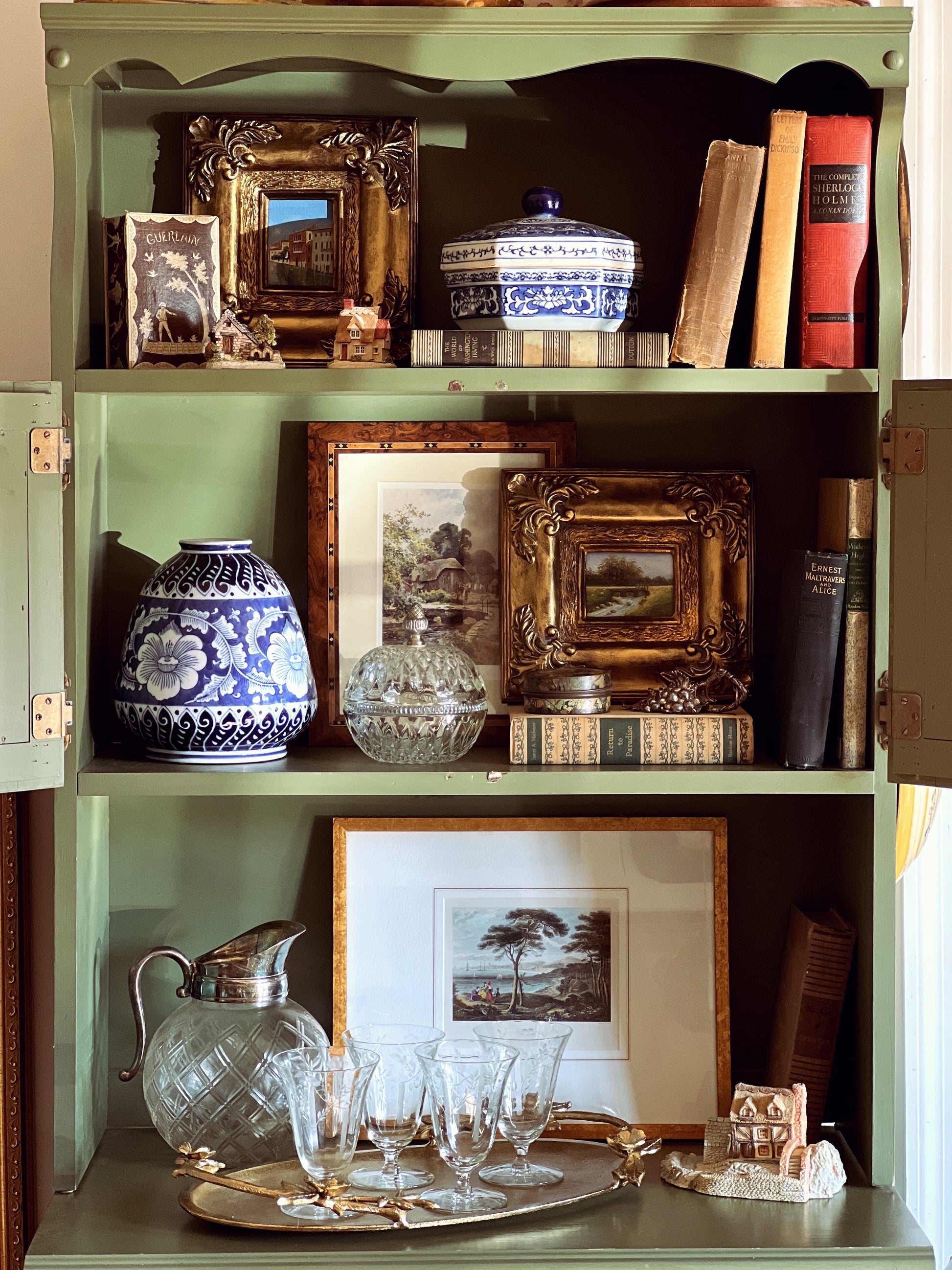 Decorative bookshelf with various items including vases, books, and framed pictures.
