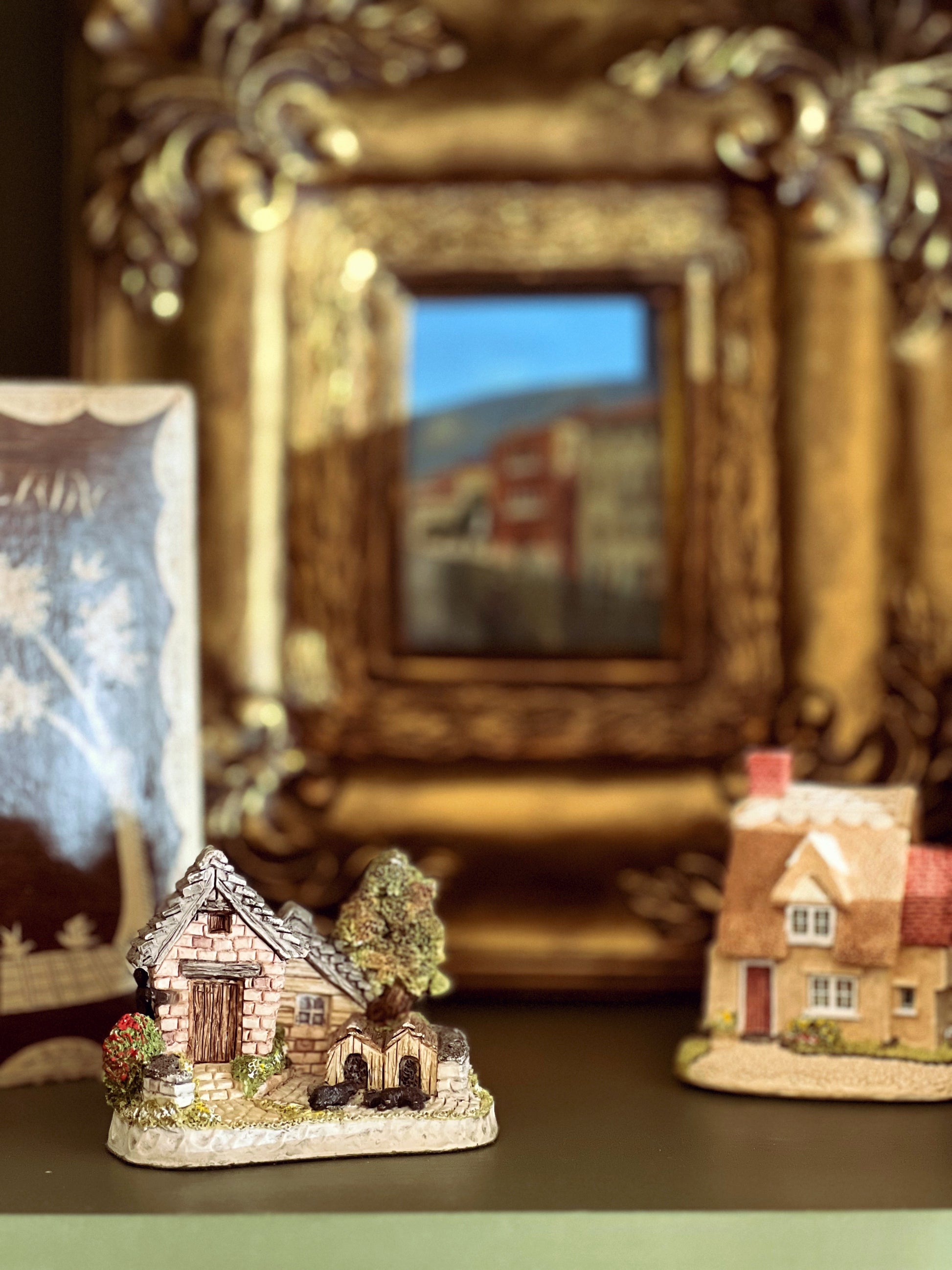 Two miniature houses with a decorative mirror in the background