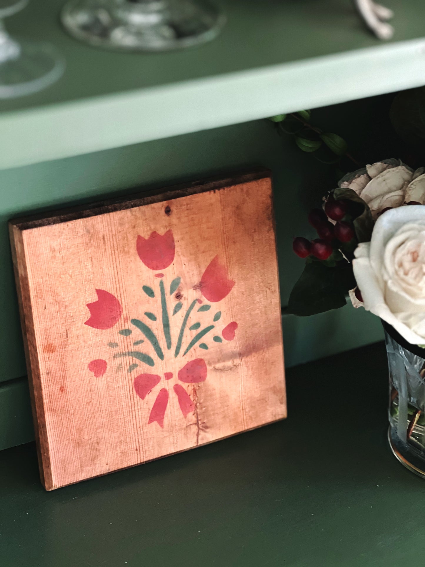 stenciled plaque leaning on a shelf