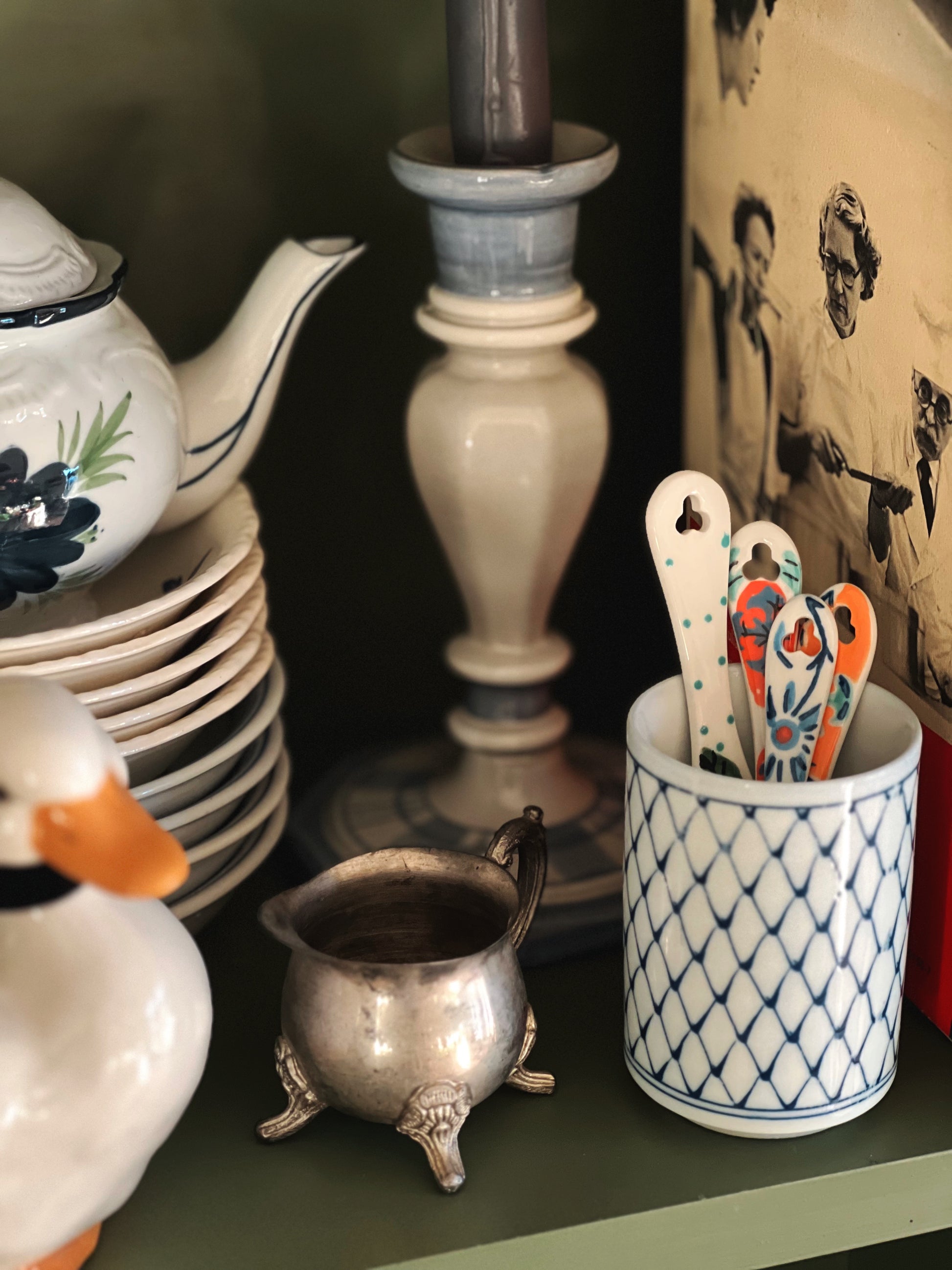 ceramic measuring spoons in a vintage cup on a shelf