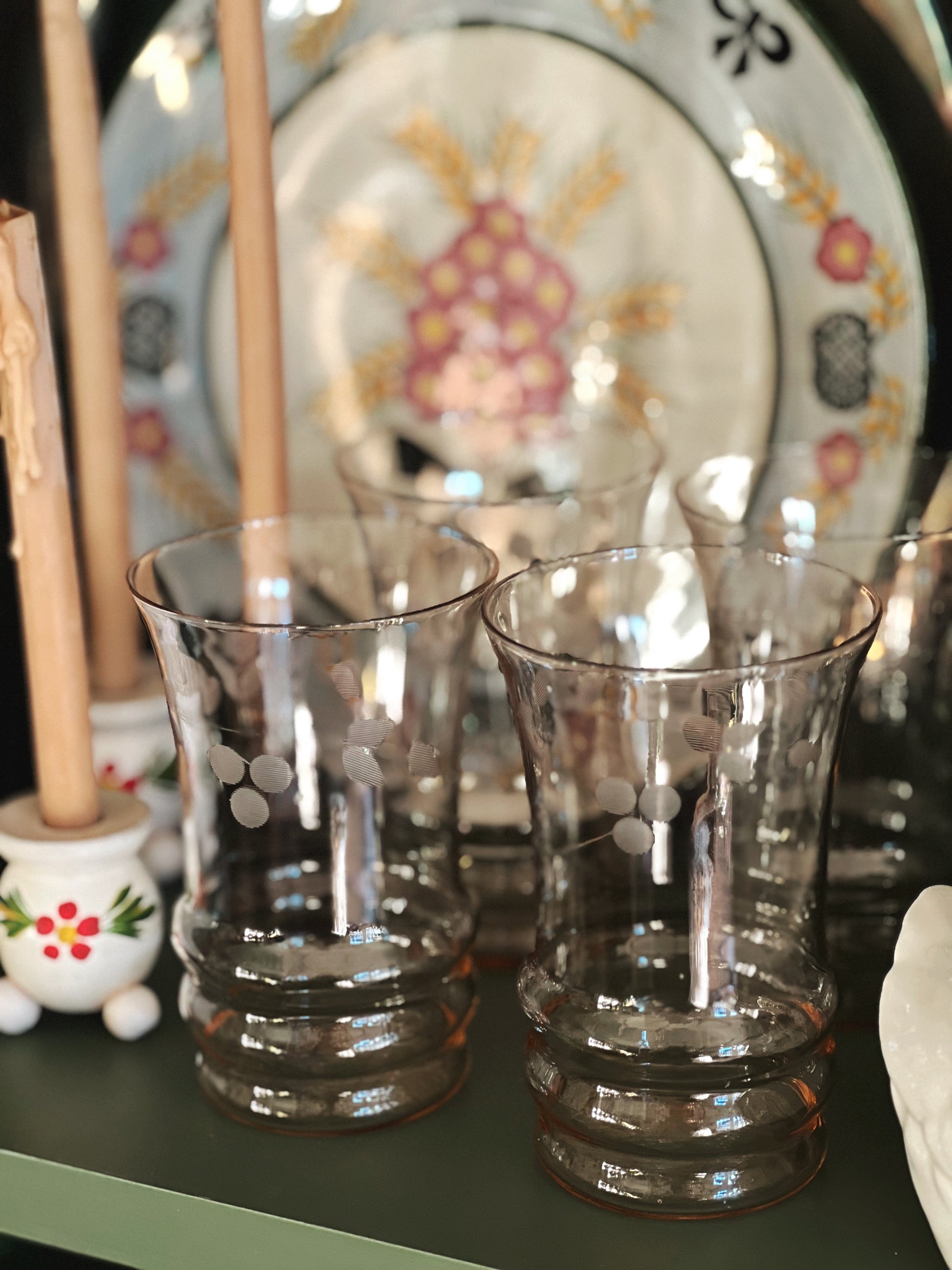 pink glass juice glasses on a shelf