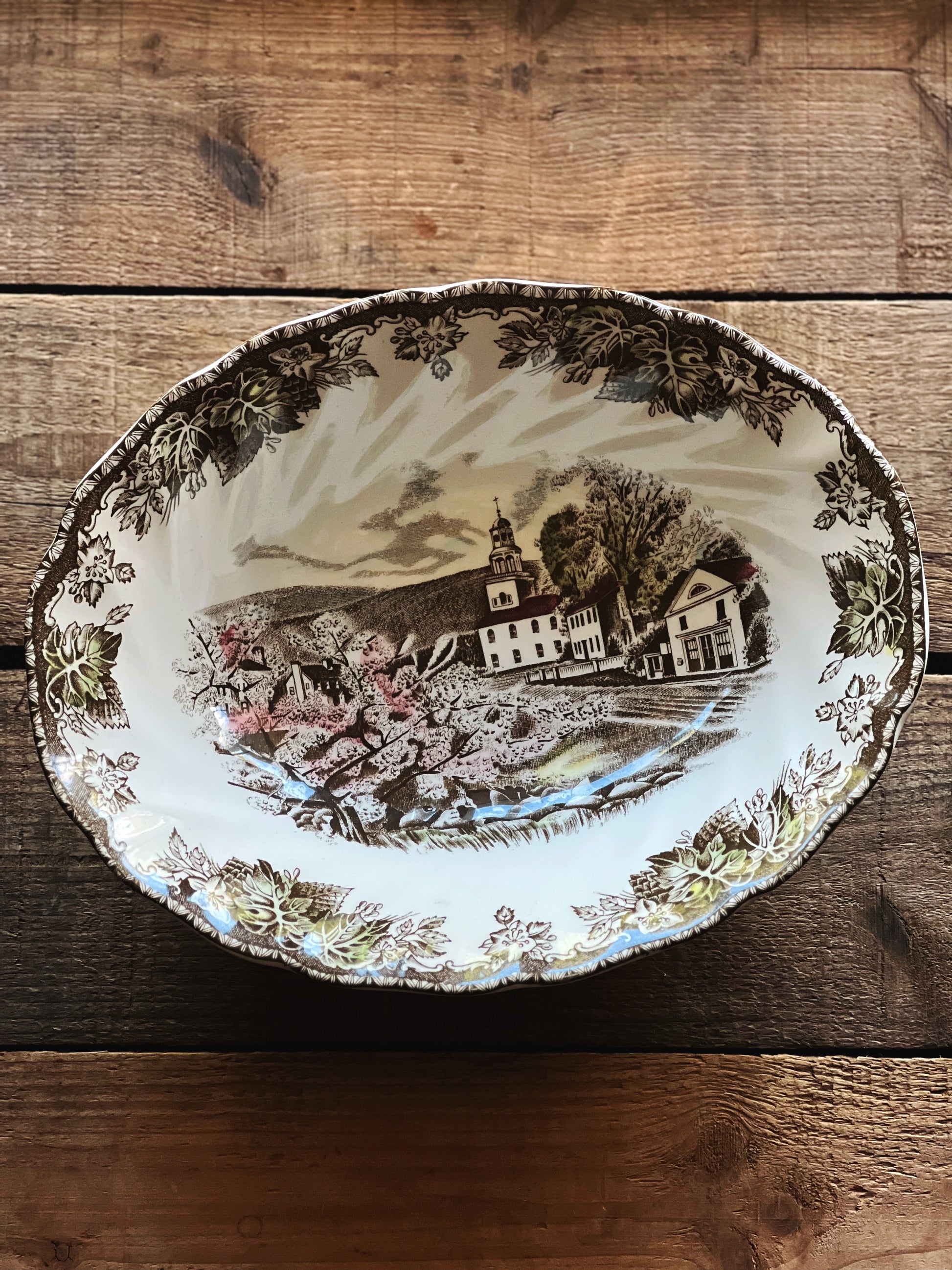Decorative plate with a scenic design on a wooden surface